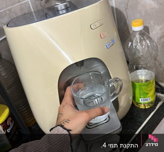 מכונת מים עם כוס ביד